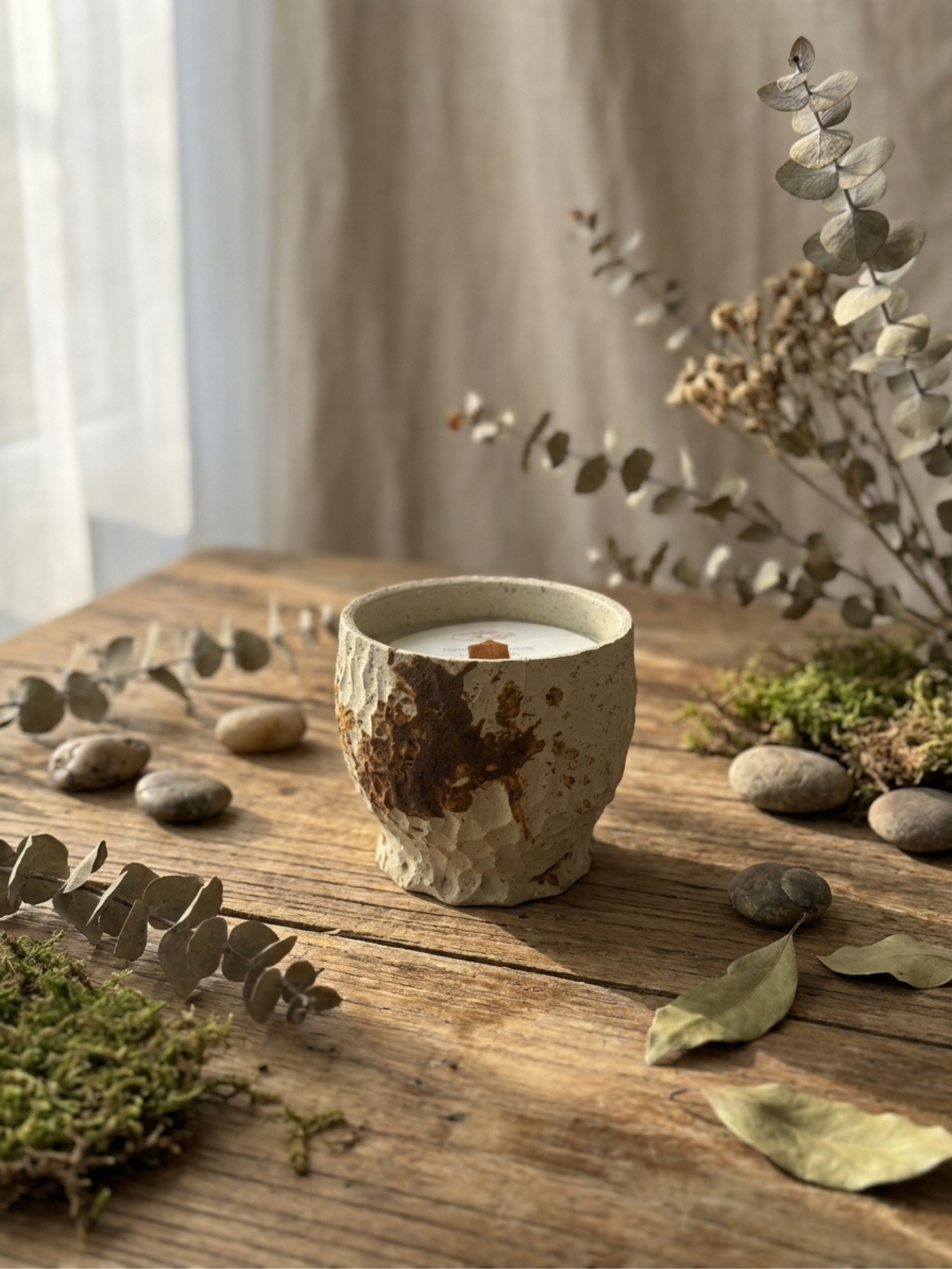 A FuLau ceramic candle on a wooden surface with soft natural light